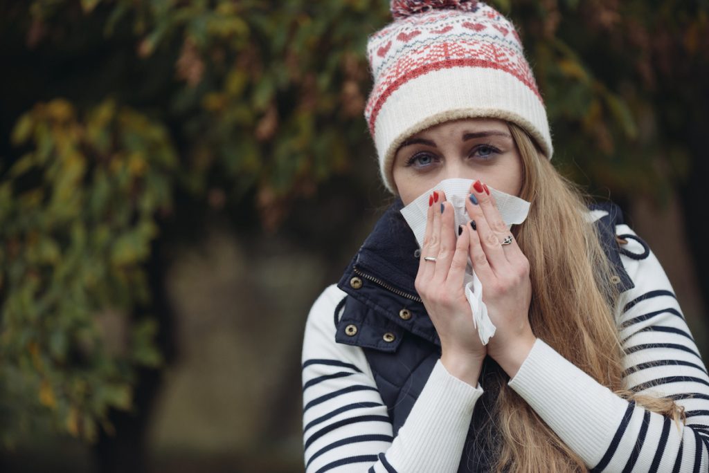 Woman Suffering From Cold outdoor with Tissue